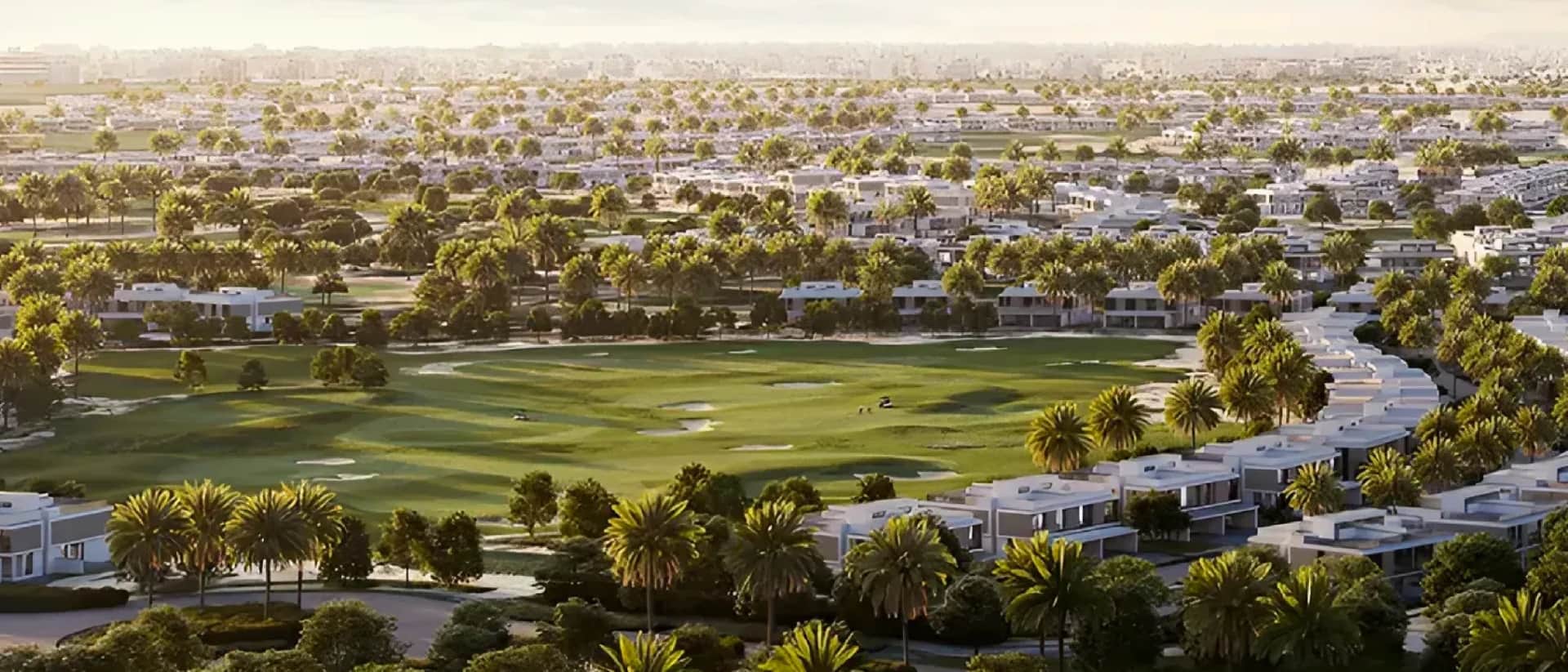 Aerial view of a golf course surrounded by modern villas and palm trees