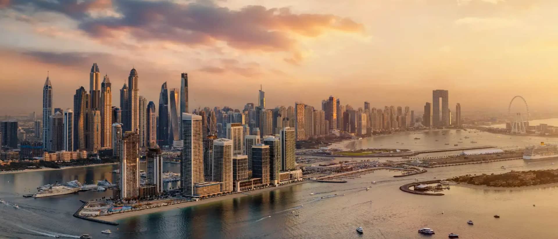 Dubai Marina skyline at sunset with boats in the water