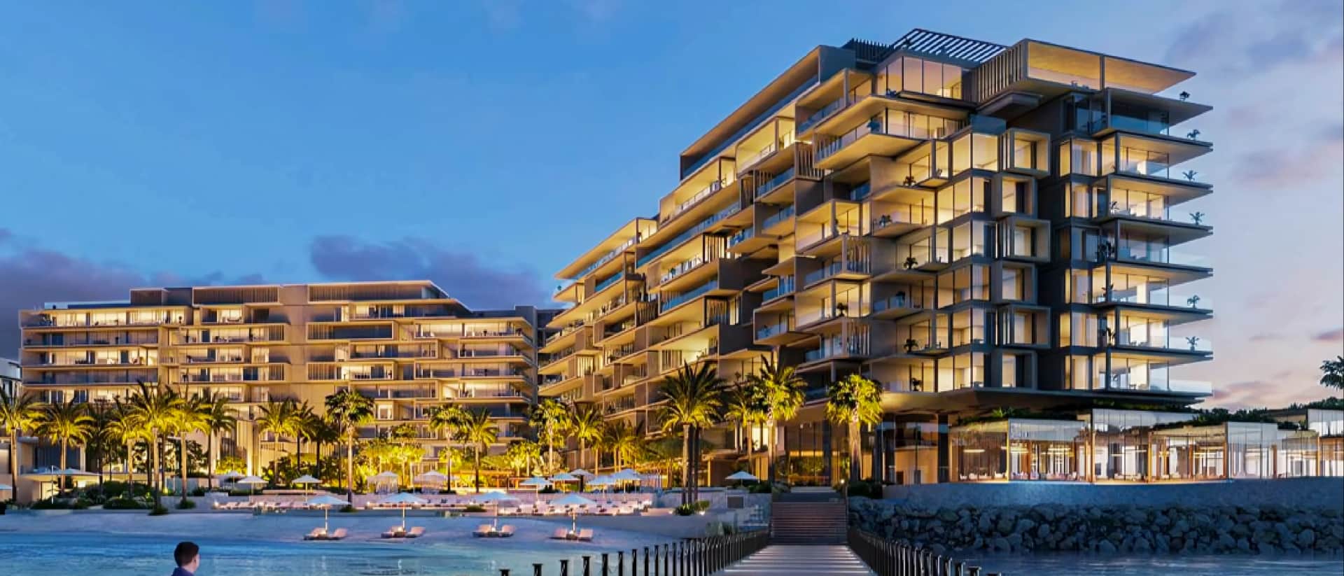 Modern beachfront resort buildings at sunset