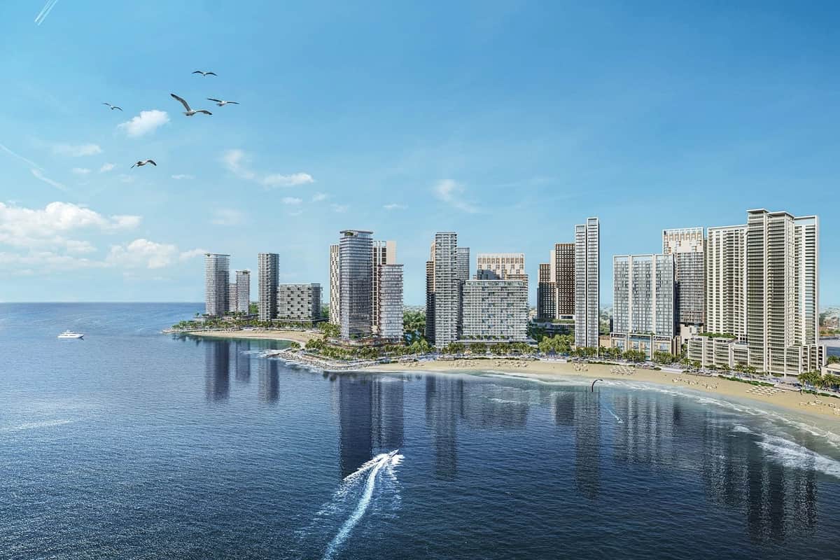 أفق مدينة ساحلية مع طيور تحلق فوق الماء