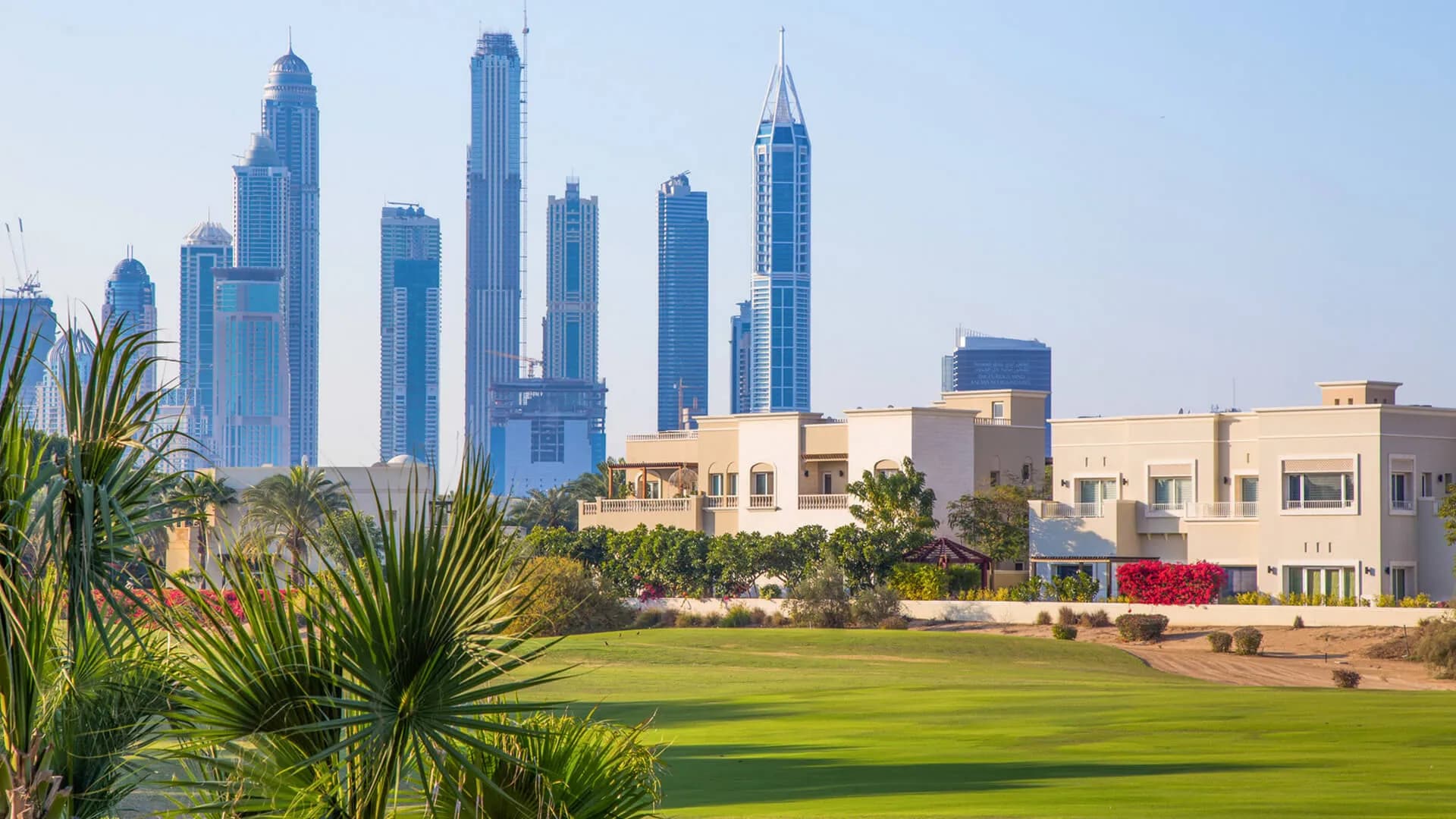 Panoramic view of Dubai's skyline with golf course and Burj Khalifa in the distance