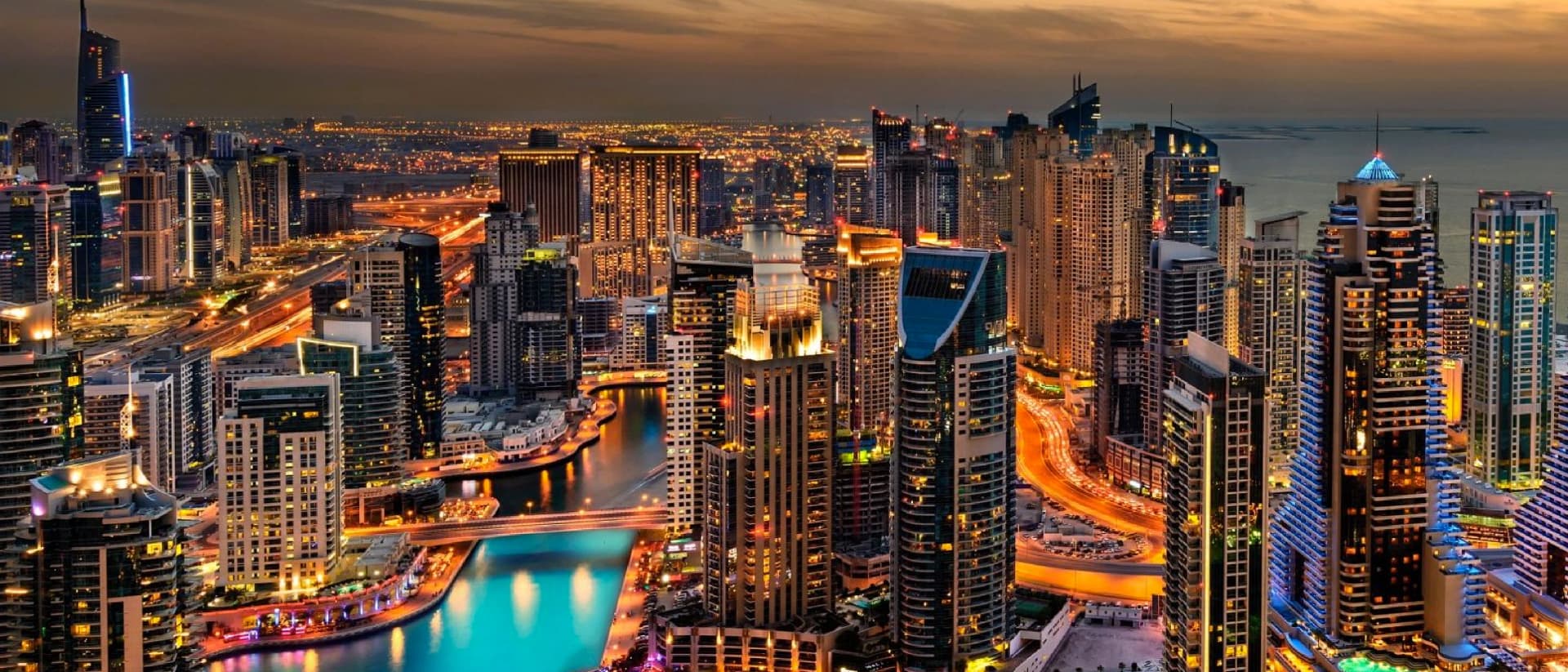 Aerial view of Dubai Marina at night, showcasing illuminated skyscrapers and waterways