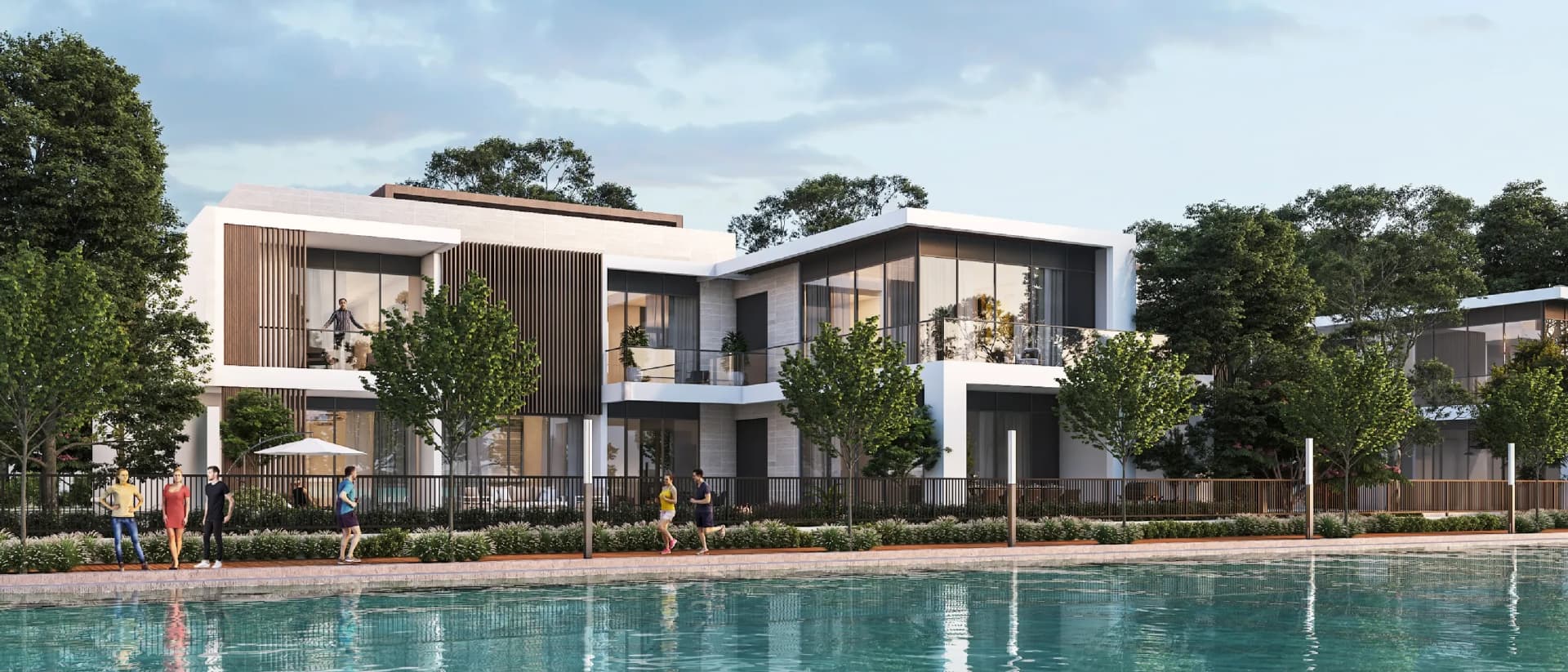 Modern houses with large windows are situated by a body of water