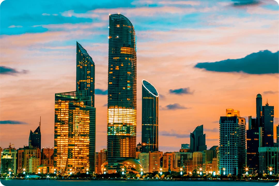 Abu Dhabi skyline at sunset with illuminated skyscrapers
