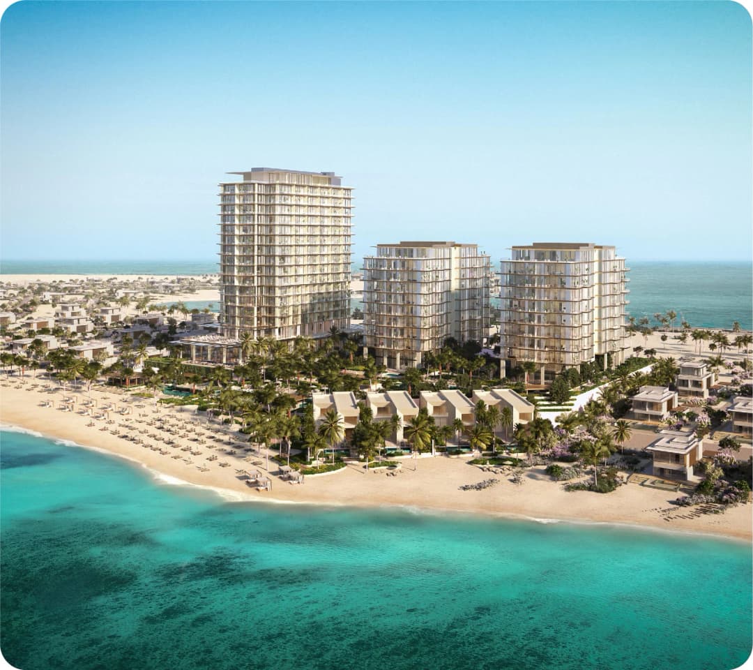 Elegant residential towers surrounded by palm trees and a clear blue sea