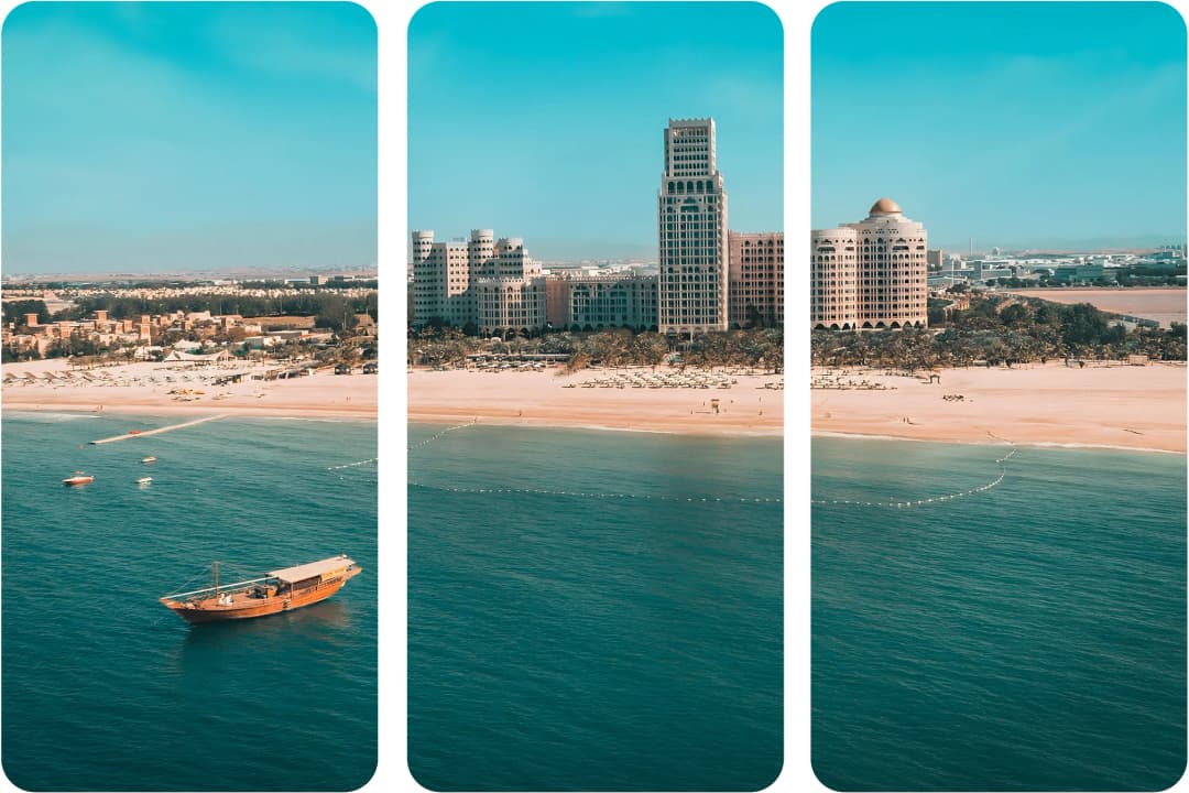 Aerial view of a beach, boat, and luxury resort in Ras Al Khaimah