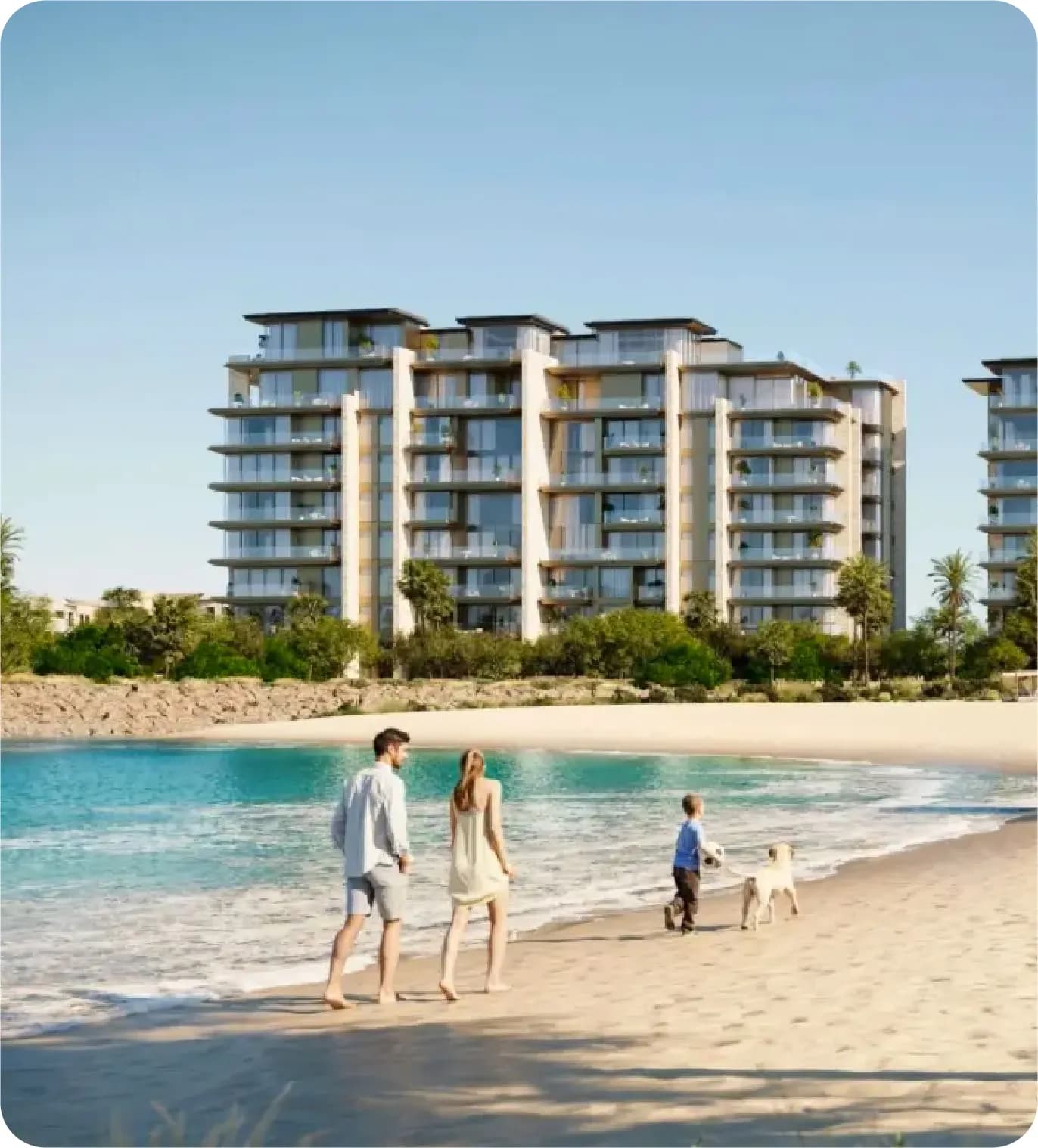 A family walking on the beach with a dog, with apartments in the background
