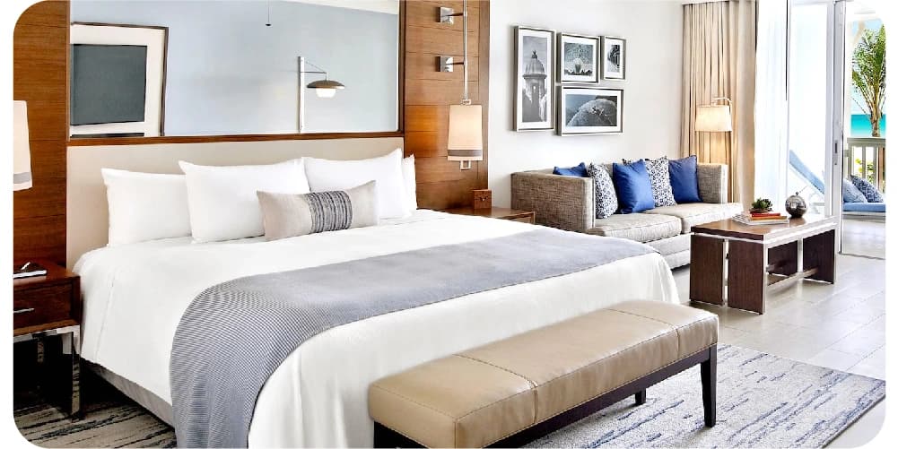 Modern hotel room with a king-size bed and seating area