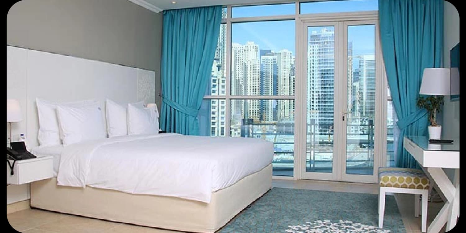 bedroom with city view through large windows