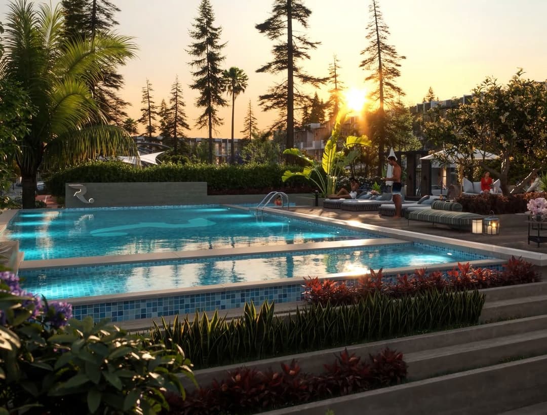 Poolside at sunset with lush greenery and lounge chairs