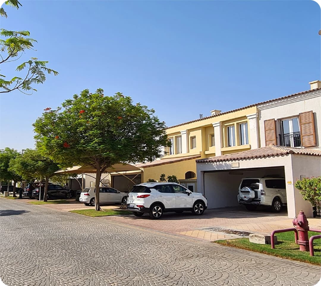 A quiet suburban street with parked cars and houses