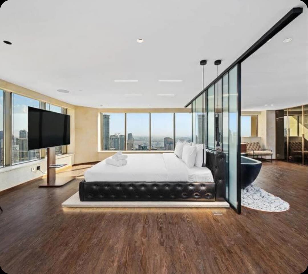Modern duplex bedroom with city view and bathtub