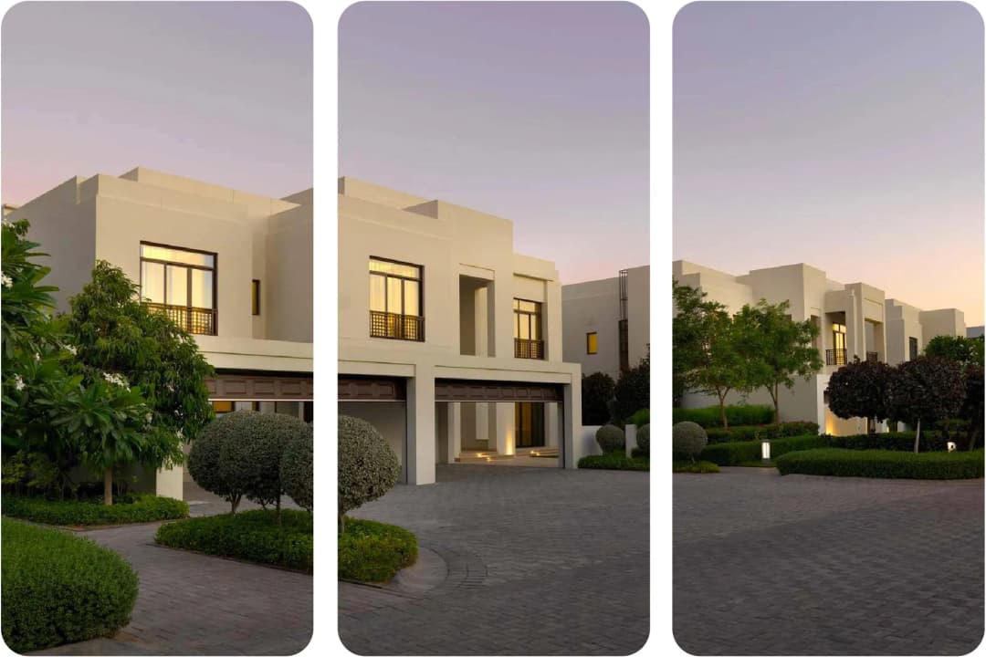 Elegant white villas with lush green landscaping at sunset