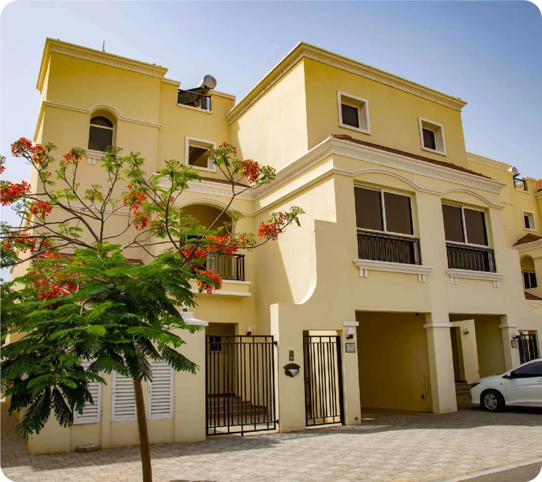 Yellow townhouse with vibrant tree in front