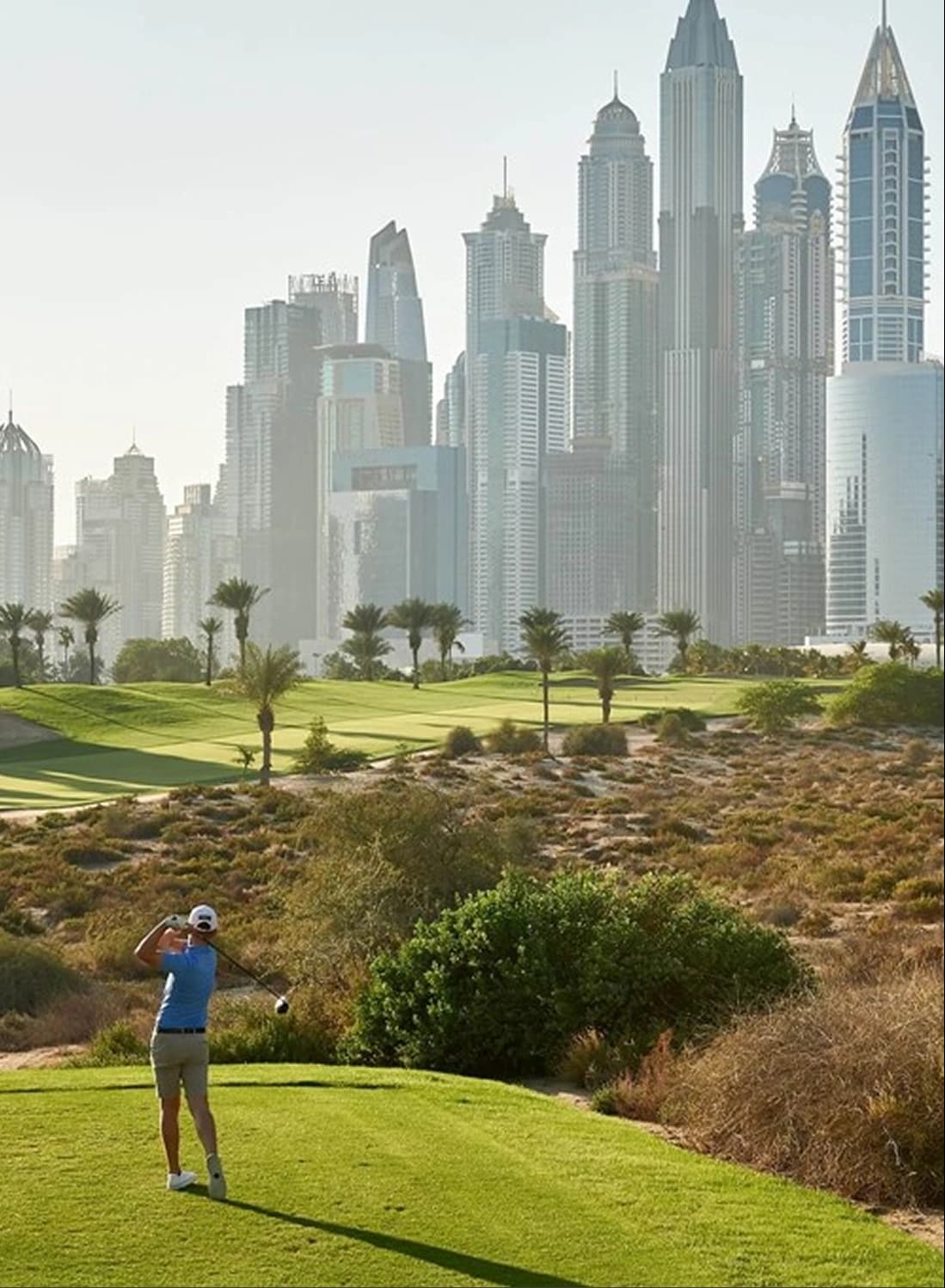 Golfer on course with Dubai's skyscrapers in view