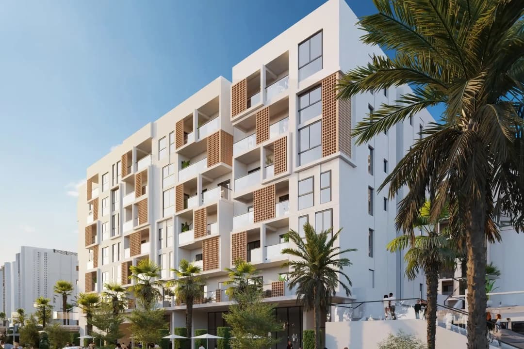 Modern apartment building with palm trees and blue skies