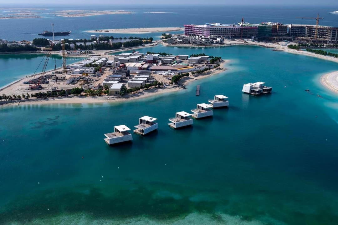 Aerial view of floating villas and a construction site by the sea