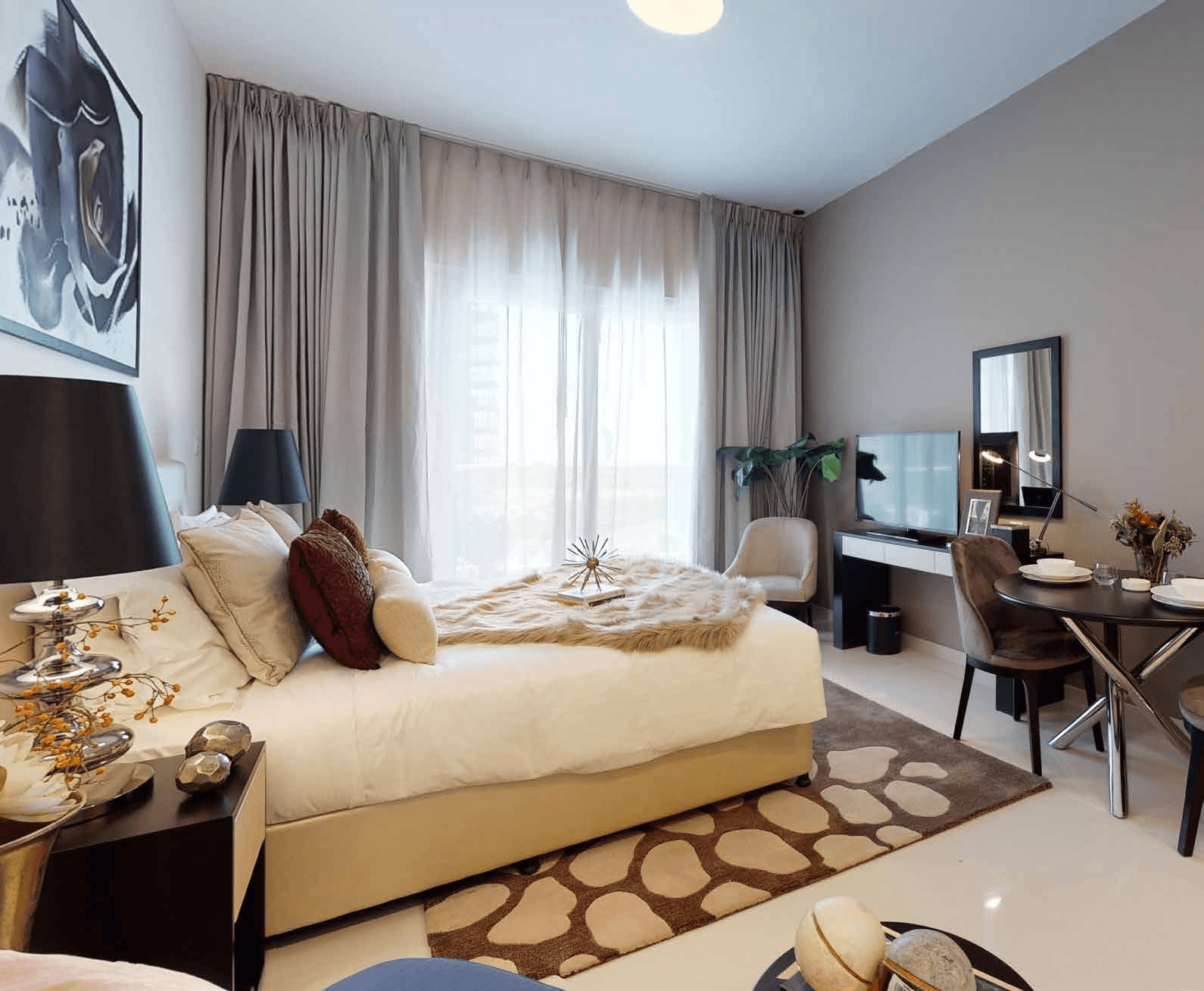 Modern cozy bedroom with stylish decor, TV, and dining area