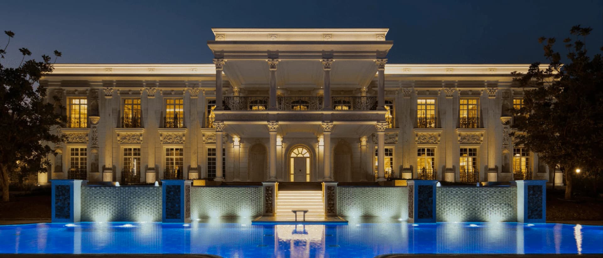 A beautiful villa with a swimming pool surrounded by lush greenery and palm trees