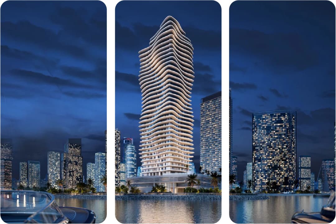 Night view of a sleek, curvy residential tower by the water