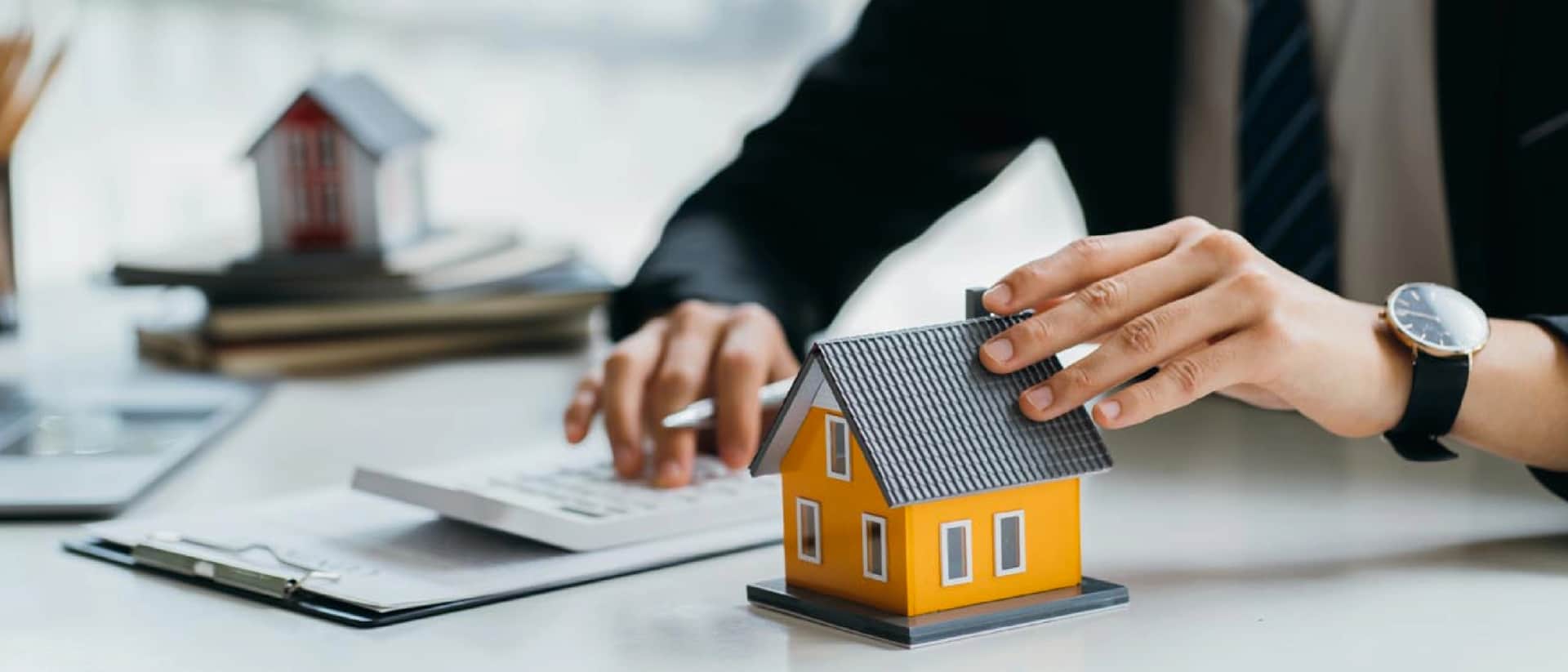 A person calculates the value of a model house