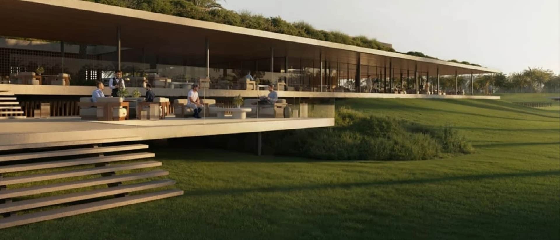 Modern building with outdoor seating overlooking a green landscape
