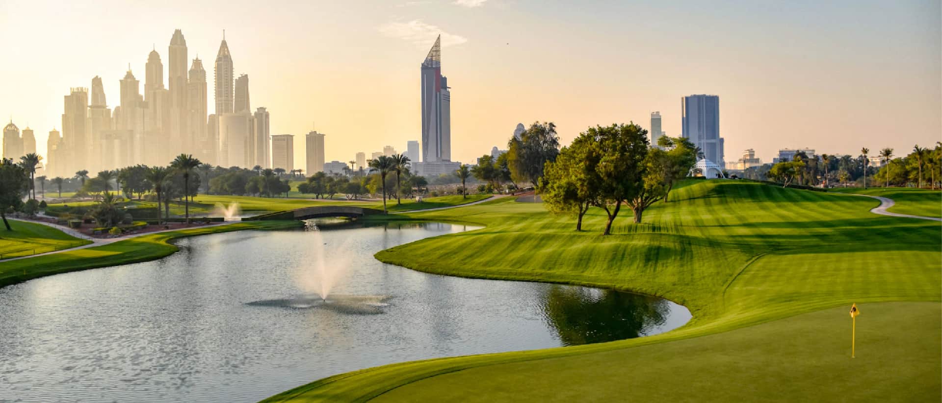 Scenic view of a golf course with Dubai skyline in the background